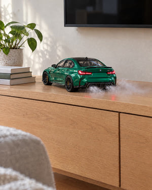 Green BMW M3 MistGarage model car with mist from the exhaust on a living room sideboard